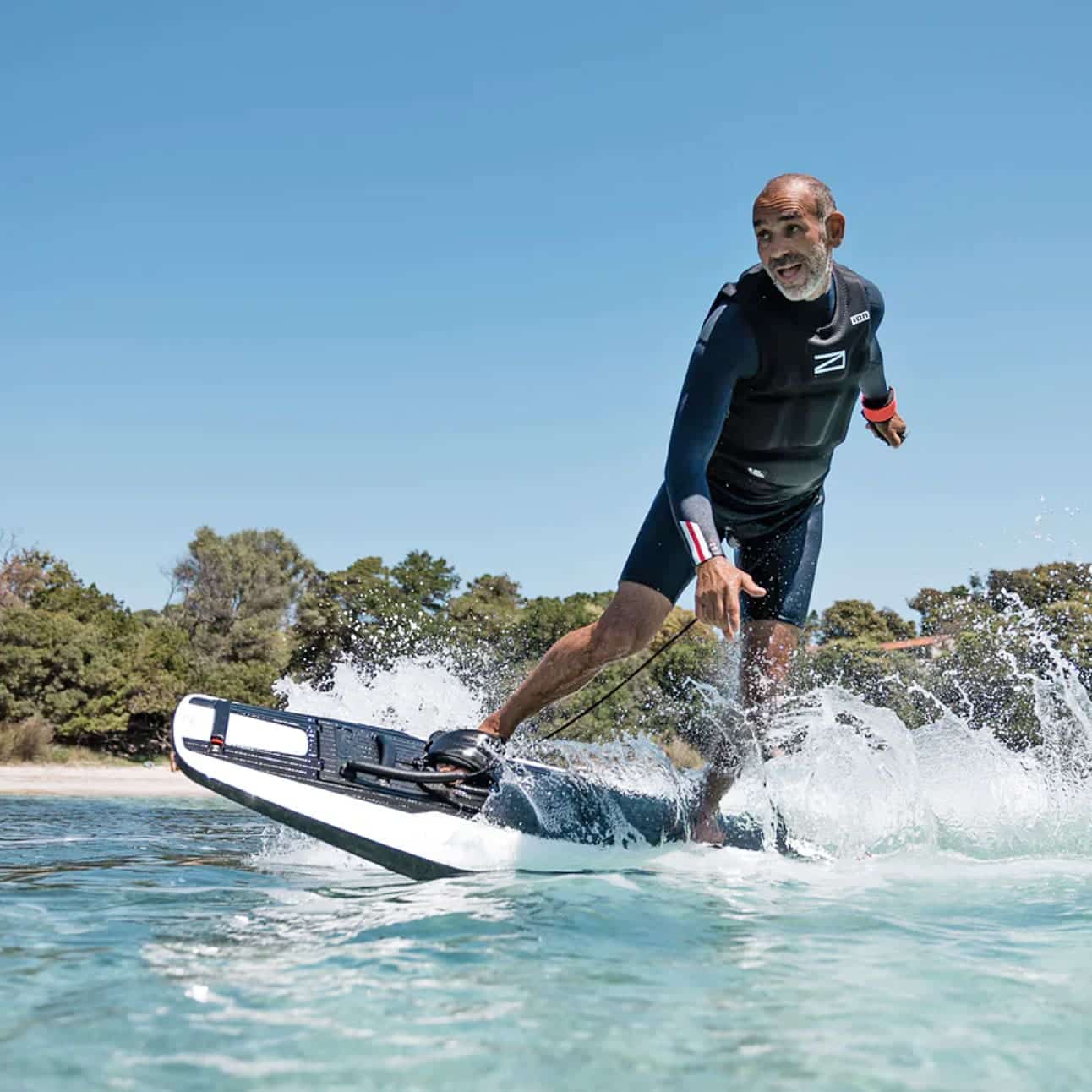 A man riding the Awake RÄVIK 3 surfboard in the water.