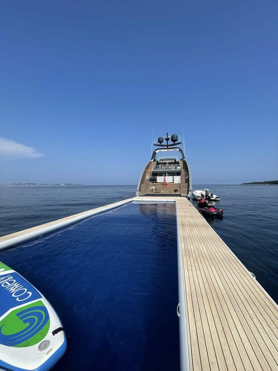 A yacht with a swimming pool and a paddle board, available for hire through sytt.