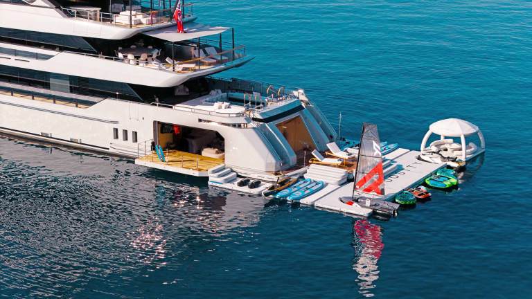 Inflatable platforms with water toys on attached to the stern of a large yacht