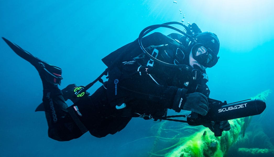 A small submarine being deployed into the water from a yacht