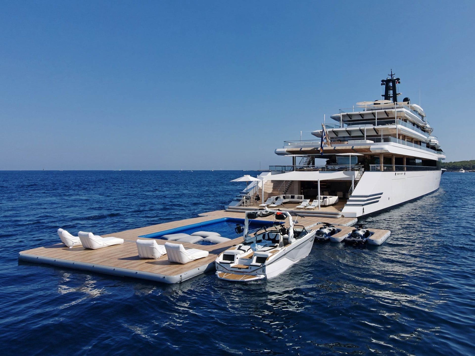 Inflatable platforms with water toys on attached to the stern of a large yacht
