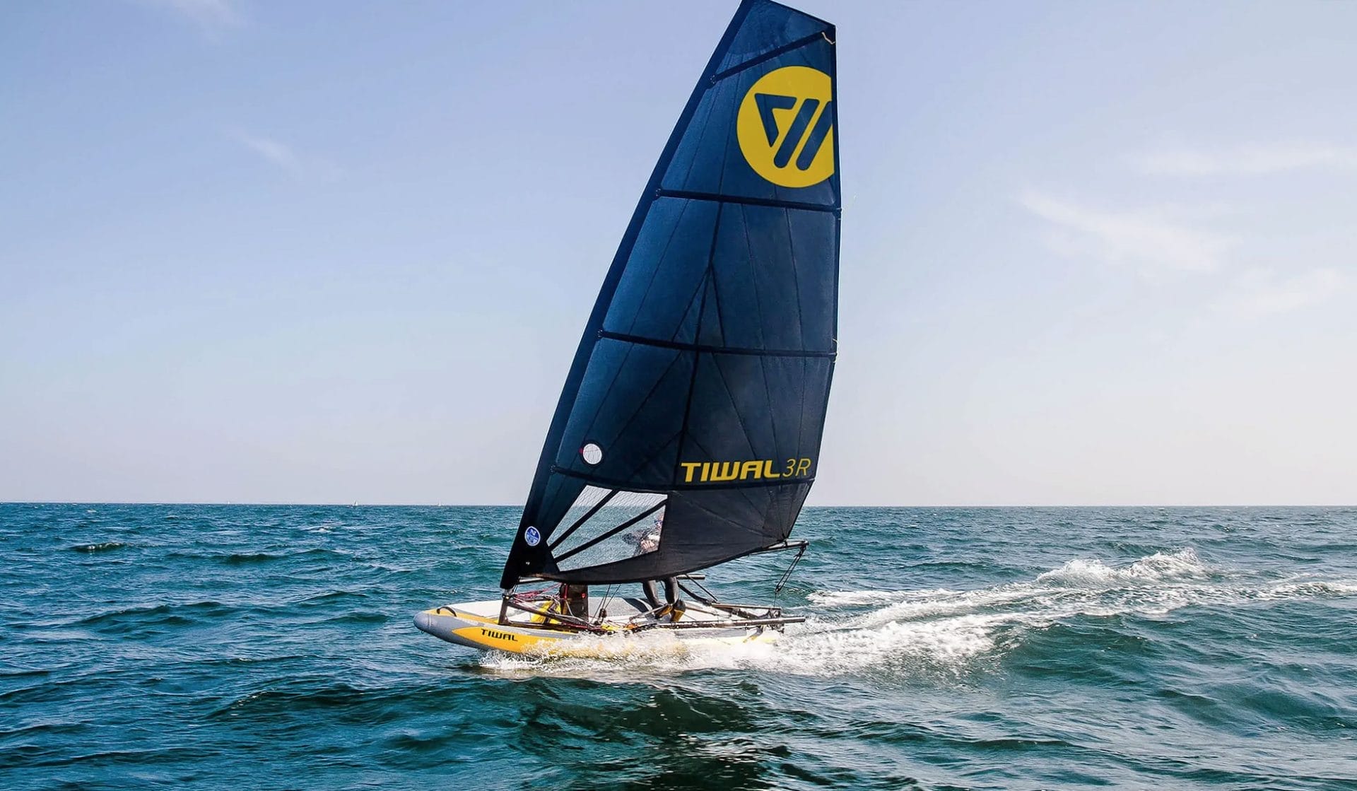 A man riding the Awake RÄVIK 3 surfboard in the water.