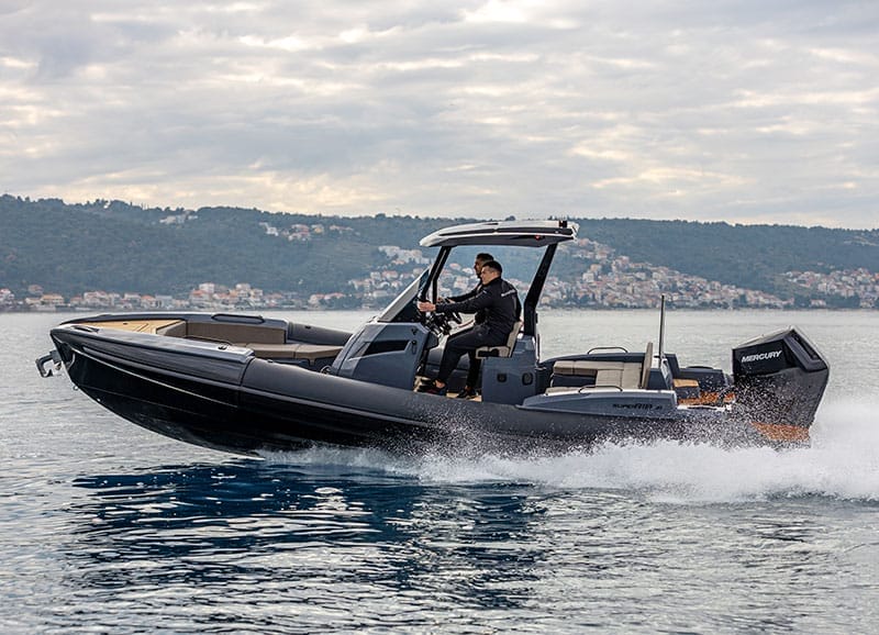 A rigid inflatable boat driving past a superyacht