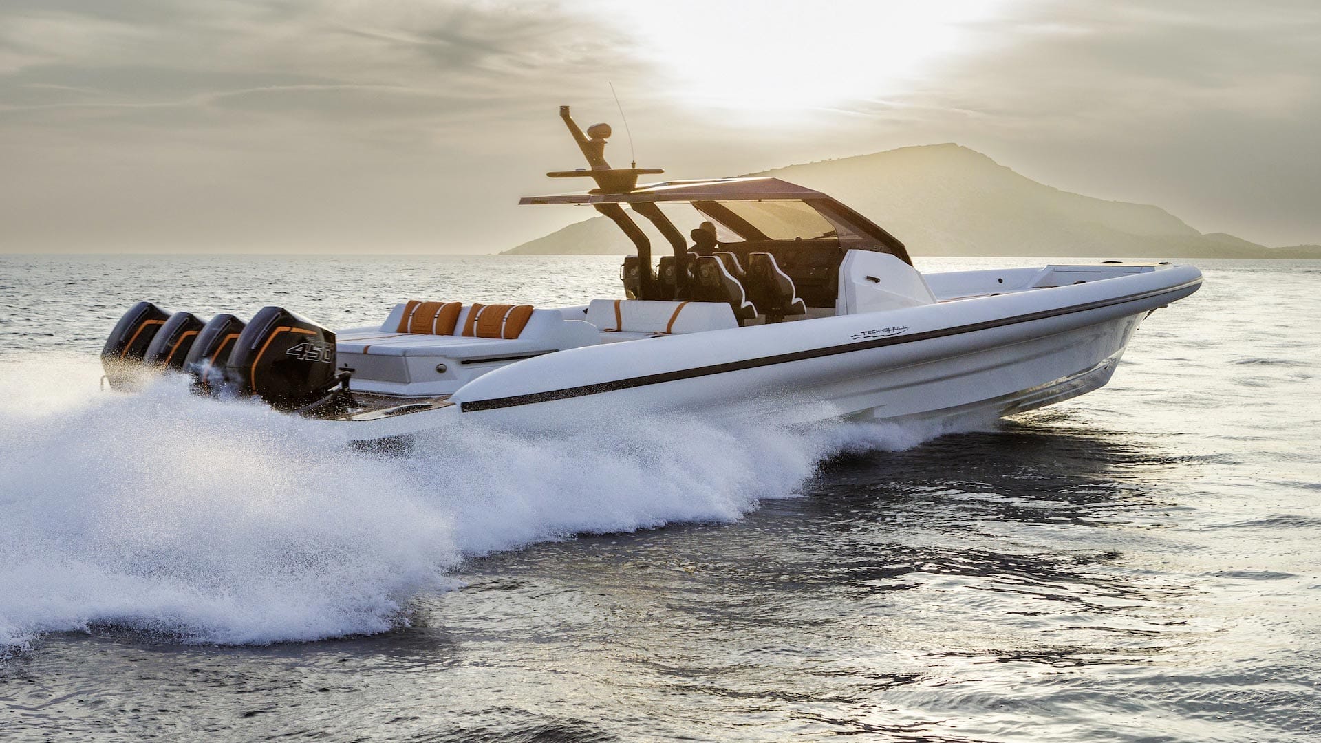A rigid inflatable boat driving past a superyacht